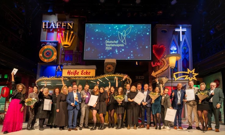 Strahlende Sieger beim Deutschen Tourismuspreis 2024: Die Gewinner und Finalisten präsentieren ihre Auszeichnungen auf der Bühne in Hamburg. Nachhaltige und innovative Projekte standen in diesem Jahr im Mittelpunkt der Preisverleihung. © Deutscher Tourismusverband e.V.