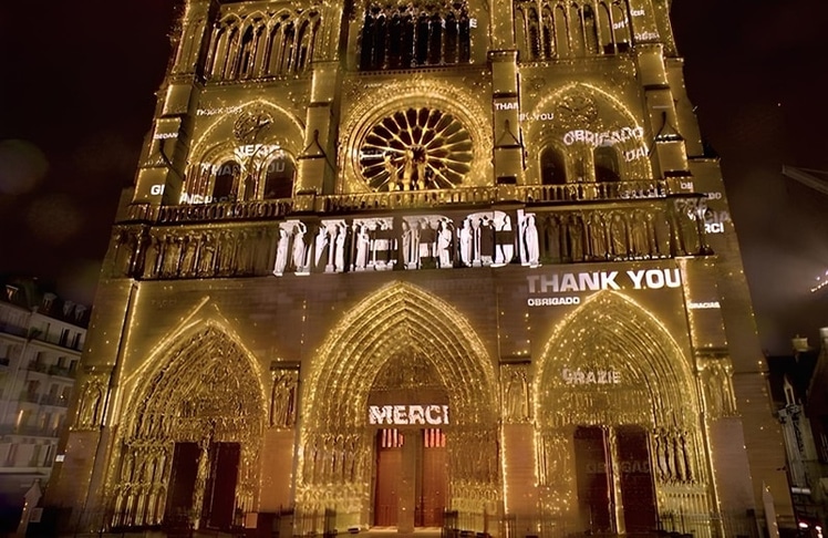 Die Fassade von Notre-Dame wurde zum Staatsakt hell erleuchtet und mit der Vokabel für "Danke" in verschiedenen Sprachen geschmückt (Bild: Emmanuel Macron auf X / Französisches Präsidialamt)